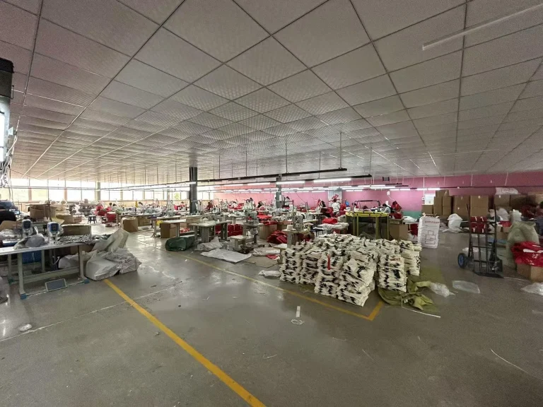 Canvas tote bag factory workshop with cut fabric and sewing stations