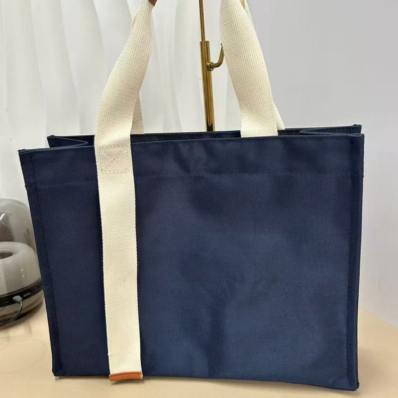 Navy oxford cloth tote bag with cream webbing handles stitched down the front panel